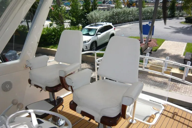 Bella Donna Yacht Photos Pics Captain's chairs on 1999 Ocean Yachts 56, overlooking marina with parked cars.