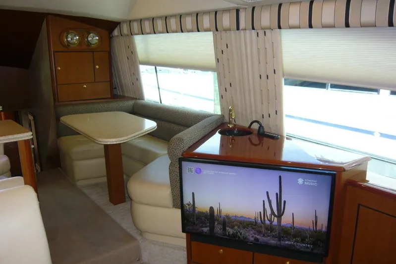 Bella Donna Yacht Photos Pics Luxurious interior of a 1999 Ocean Yachts 56, featuring a cozy dining area and modern TV setup.