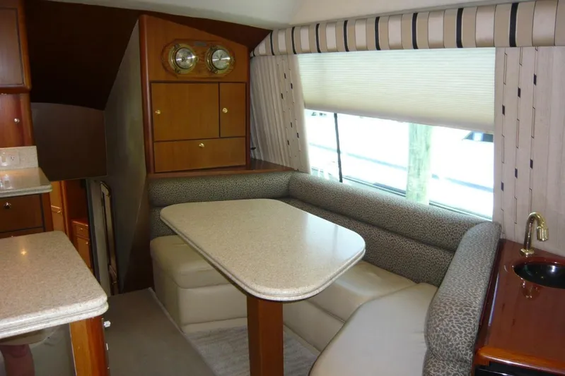 Bella Donna Yacht Photos Pics Interior of 1999 Ocean Yachts 56, featuring a cozy dining area with a table and seating.