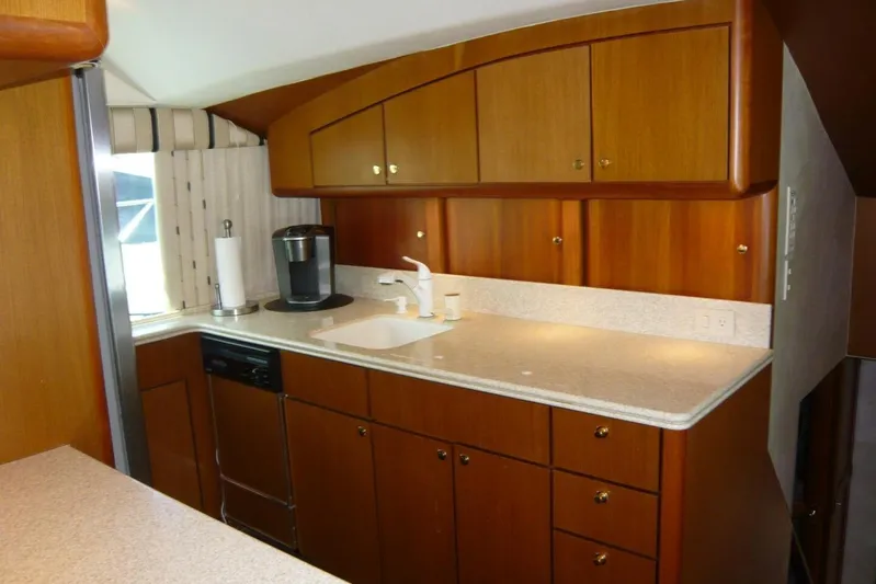 Bella Donna Yacht Photos Pics Luxurious 1999 Ocean Yachts 56 kitchen with wooden cabinets and modern appliances.