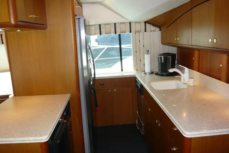 Bella Donna Yacht Photos Pics 1999 Ocean Yachts 56 kitchen with wood cabinets, modern appliances, and ample counter space.