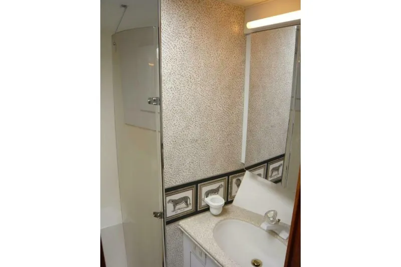 Bella Donna Yacht Photos Pics Bathroom interior of 1999 Ocean Yachts 56, featuring a sink and decorative wall tiles.
