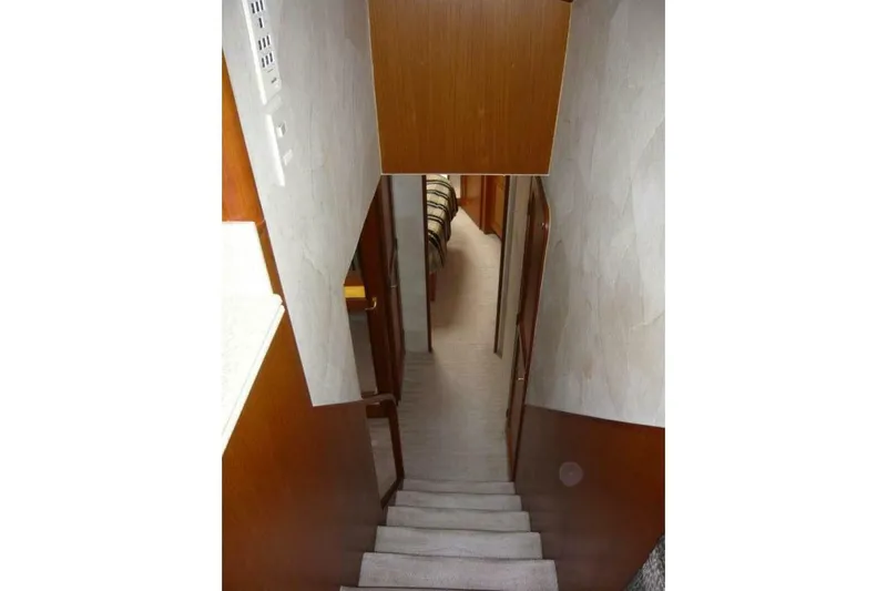 Bella Donna Yacht Photos Pics Staircase inside 1999 Ocean Yachts 56, featuring wooden paneling and carpeted steps.