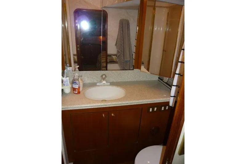 Bella Donna Yacht Photos Pics Bathroom interior of 1999 Ocean Yachts 56, featuring a sink, mirror, and storage cabinets.