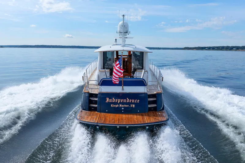 Independence Yacht Photos Pics 2009 Hunt Yachts 52 Express cruising on open water, rear view with American flag.