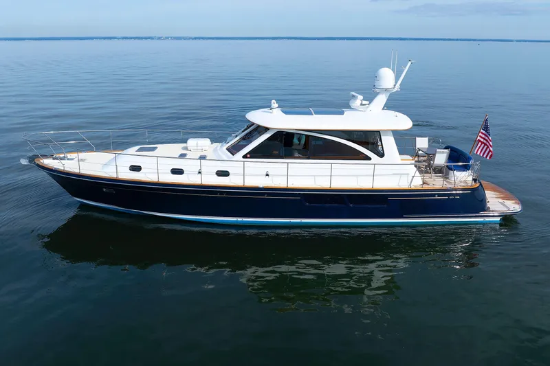 Independence Yacht Photos Pics 2009 Hunt Yachts 52 Express cruising on calm waters, featuring sleek design and American flag.