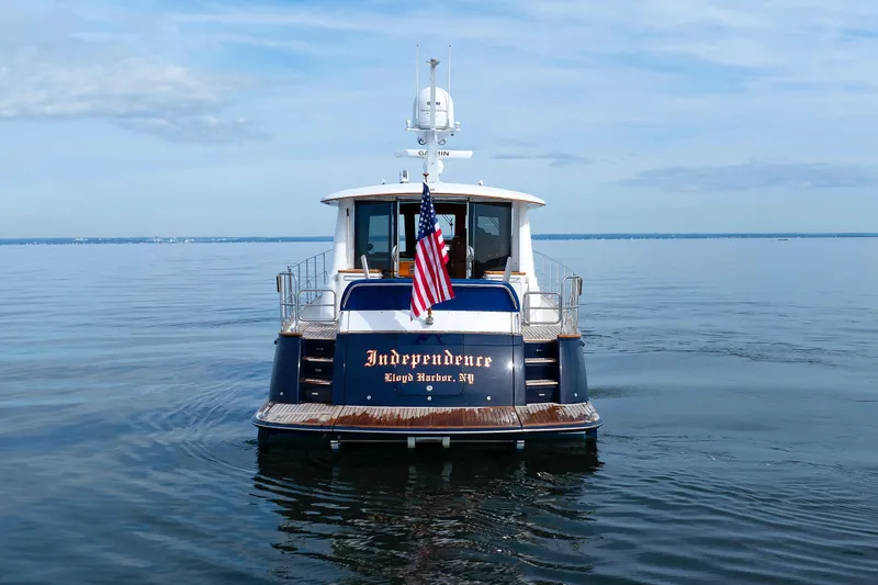 Independence Yacht Photos Pics 2009 Hunt Yachts 52 Express on calm water, displaying American flag.