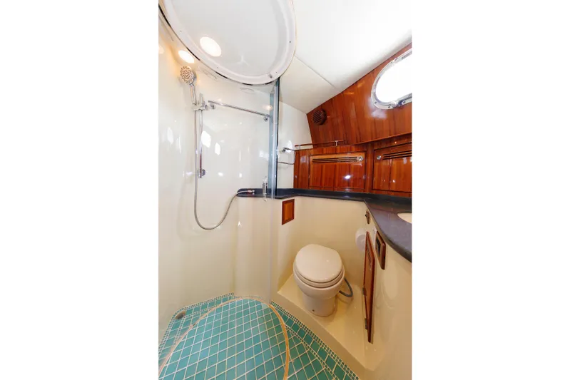Independence Yacht Photos Pics Luxurious bathroom in 2009 Hunt Yachts 52 Express, featuring shower and wooden cabinetry.