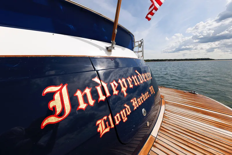 Independence Yacht Photos Pics 2009 Hunt Yachts 52 Express named "Independence" on water, wooden deck, American flag.