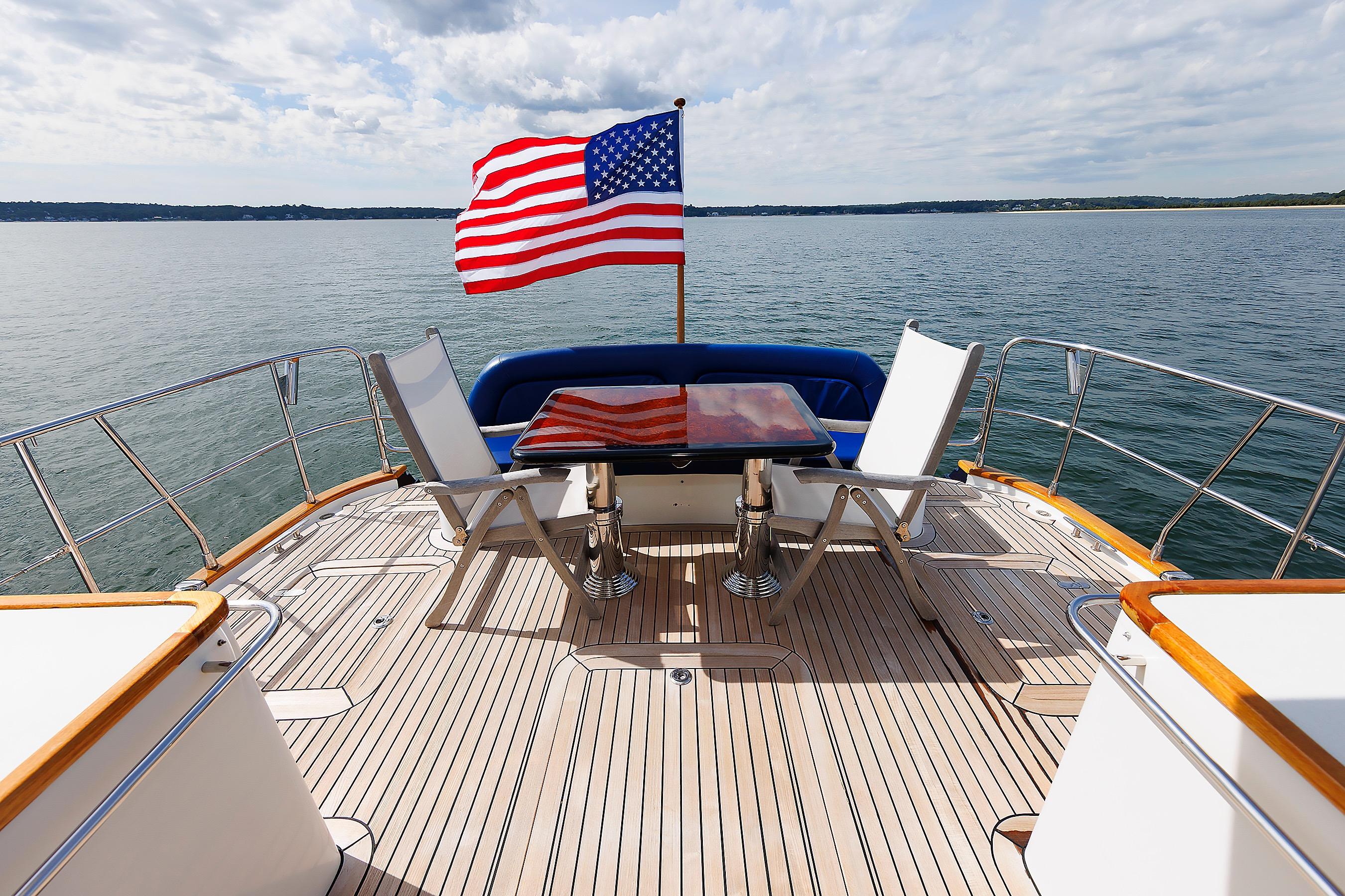 Luxury 2009 Hunt Yachts 52 Express deck with American flag, ocean view, and seating area.