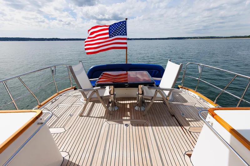 Independence Yacht Photos Pics Luxury 2009 Hunt Yachts 52 Express deck with American flag, ocean view, and seating area.