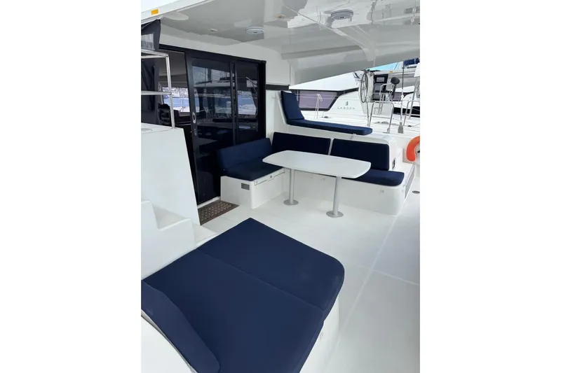  Yacht Photos Pics 2018 Lagoon 42 yacht interior with blue seating and white table.