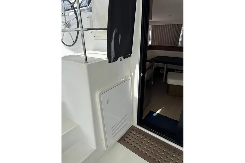  Yacht Photos Pics Interior view of a 2018 Lagoon 42 catamaran, showcasing helm and cabin entrance.