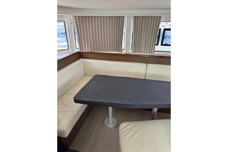  Yacht Photos Pics Interior of 2018 Lagoon 42 yacht with beige seating and a dark table.