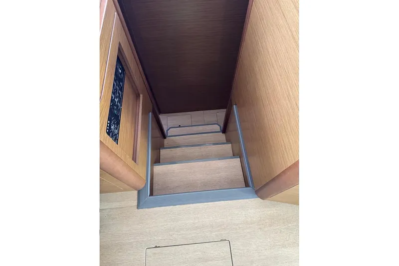  Yacht Photos Pics Interior stairs of a 2018 Lagoon 42 catamaran, featuring wooden paneling.