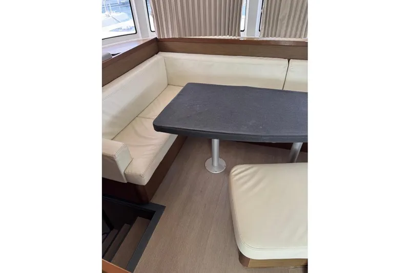  Yacht Photos Pics Interior of 2018 Lagoon 42 yacht with beige seating and dark table.