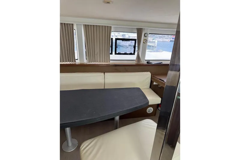  Yacht Photos Pics Interior of 2018 Lagoon 42 catamaran with seating and table, featuring large windows.