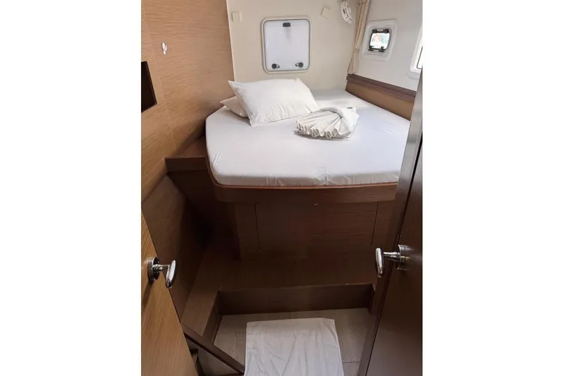  Yacht Photos Pics Cozy cabin interior of 2018 Lagoon 42 catamaran with bed and portholes.