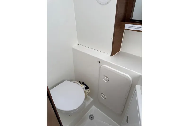  Yacht Photos Pics Compact bathroom in 2018 Lagoon 42 catamaran, featuring a toilet and storage compartment.