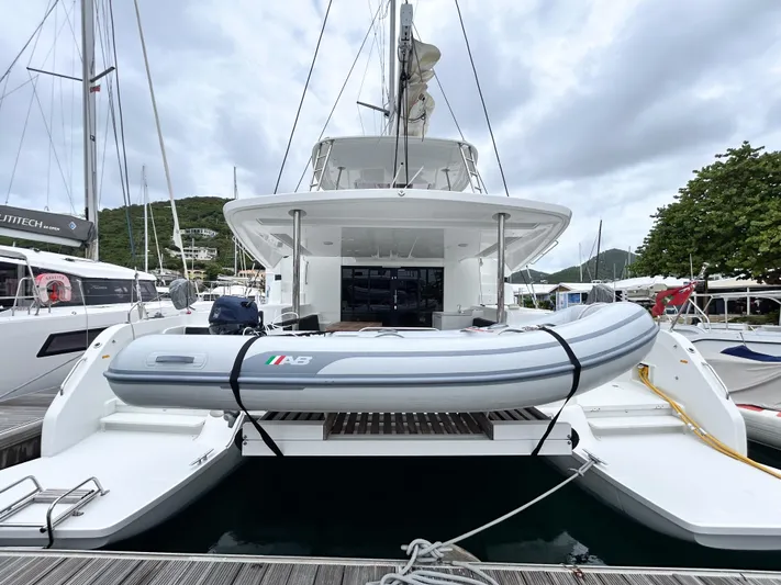 Slinky Malinki Yacht Photos Pics 2025 Lagoon 51 yacht with inflatable boat docked at marina.