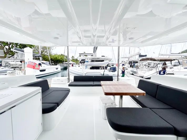 Slinky Malinki Yacht Photos Pics Spacious deck of 2025 Lagoon 51 yacht with modern seating and table.