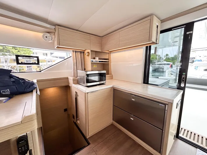 Slinky Malinki Yacht Photos Pics Modern kitchen interior of 2025 Lagoon 51 yacht with sleek cabinetry and appliances.