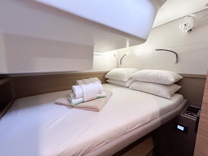 Slinky Malinki Yacht Photos Pics Cozy cabin interior of 2025 Lagoon 51 yacht with neatly arranged bedding.