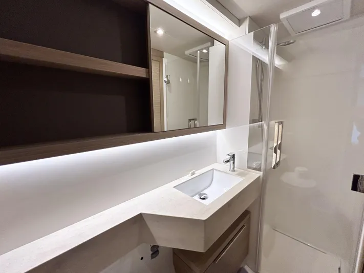 Slinky Malinki Yacht Photos Pics Modern bathroom interior of 2025 Lagoon 51 yacht with sleek sink and mirror.