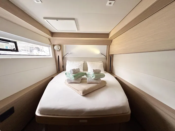 Slinky Malinki Yacht Photos Pics Luxurious cabin interior of 2025 Lagoon 51 yacht with neatly arranged bed and towels.