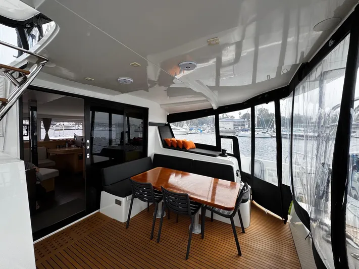 Nellie Yacht Photos Pics 2020 Lagoon 42 yacht interior with dining area, wooden table, and marina view.