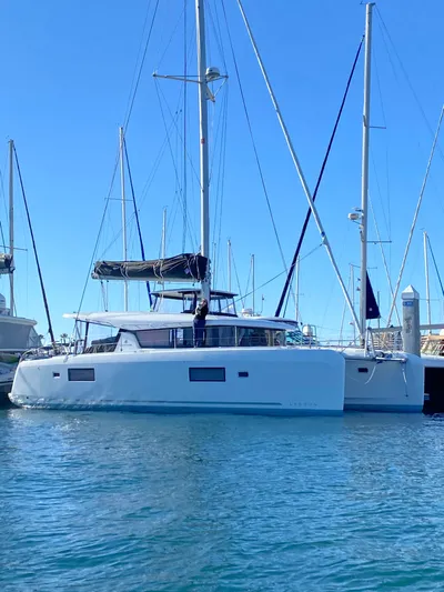 Nellie Yacht Photos Pics 2020 Lagoon 42 catamaran docked in marina under clear blue sky.