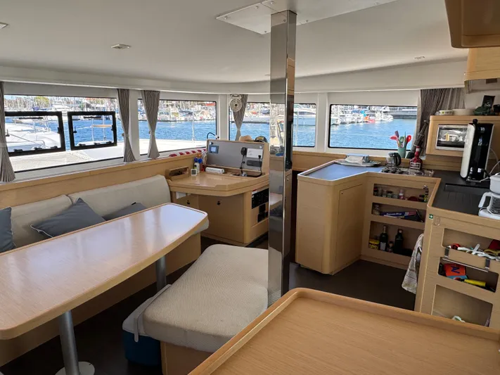 Nellie Yacht Photos Pics Interior of a 2020 Lagoon 42 catamaran with modern furnishings and scenic window views.