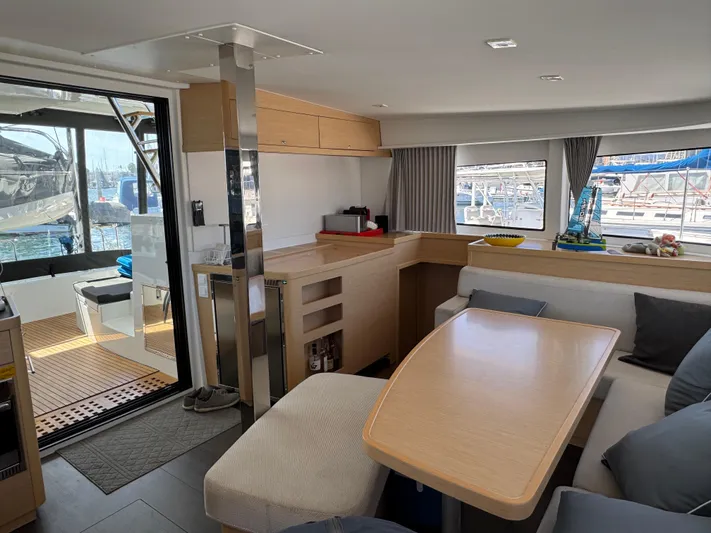 Nellie Yacht Photos Pics Interior of 2020 Lagoon 42 catamaran with modern furnishings and marina view.