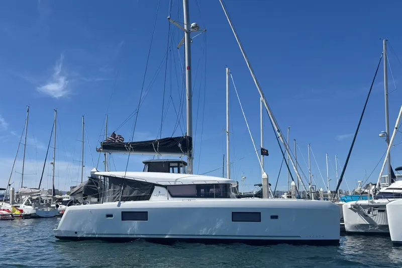 Nellie Yacht Photos Pics 2020 Lagoon 42 catamaran docked in a marina under a clear blue sky.