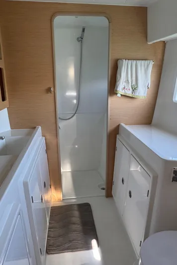 Nellie Yacht Photos Pics Modern bathroom in a 2020 Lagoon 42 yacht with shower and white cabinetry.
