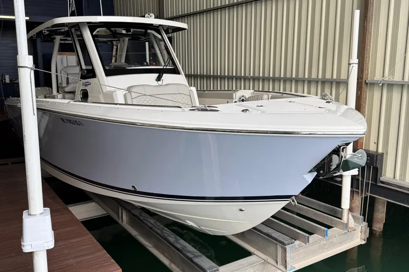  Yacht Photos Pics 2022 Pursuit S 328 Sport boat in storage, showcasing sleek design and modern features.