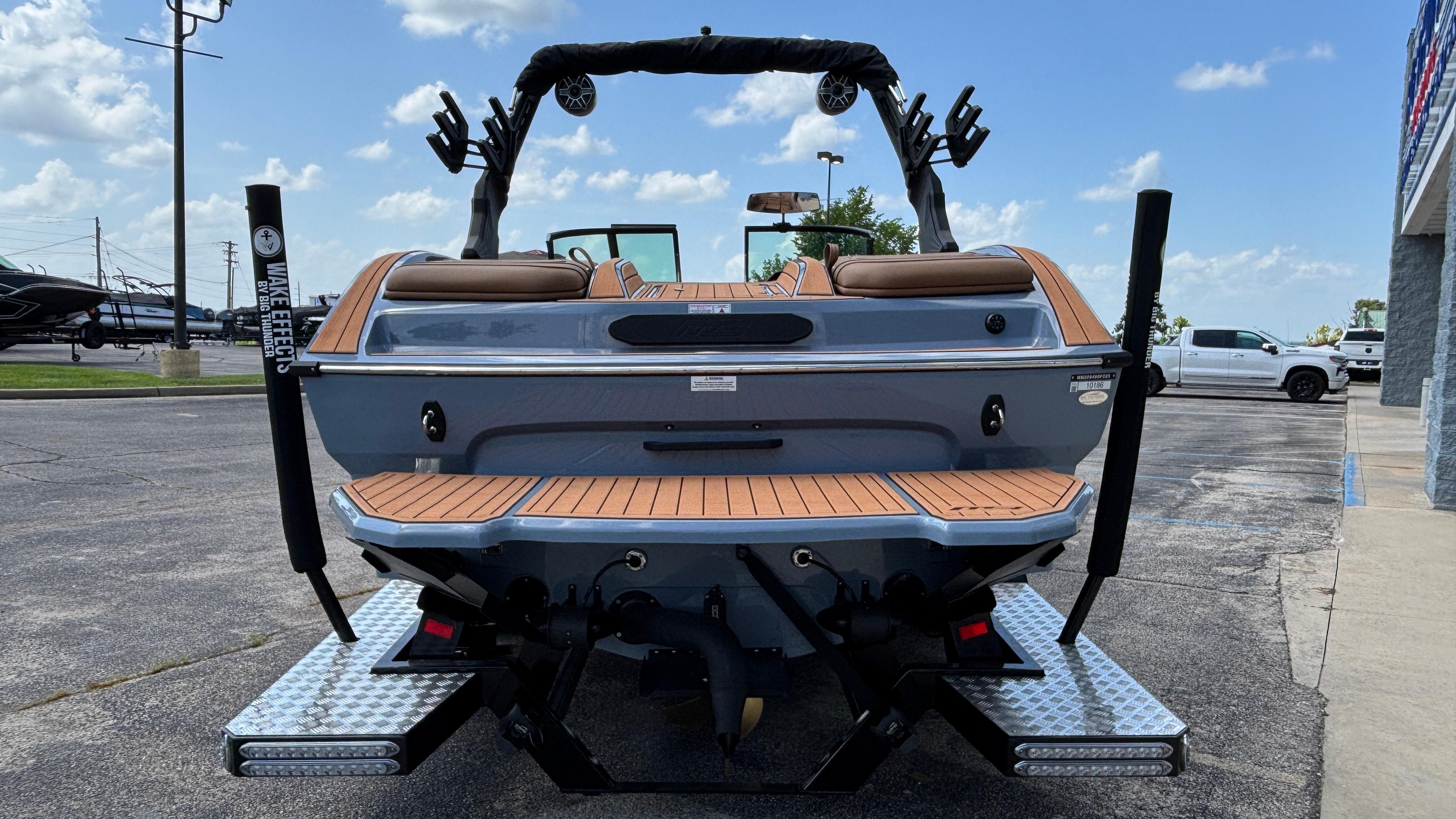 2025 MB B52 23 Alpha boat, rear view, parked outdoors on a sunny day.