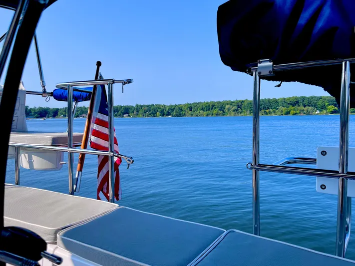 Amadeus Yacht Photos Pics Catalina 355 sailboat with American flag on serene lake, 2014 model.