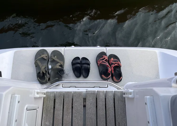 Amadeus Yacht Photos Pics Three pairs of sandals on a Catalina 355 boat deck, 2014 model, near water.