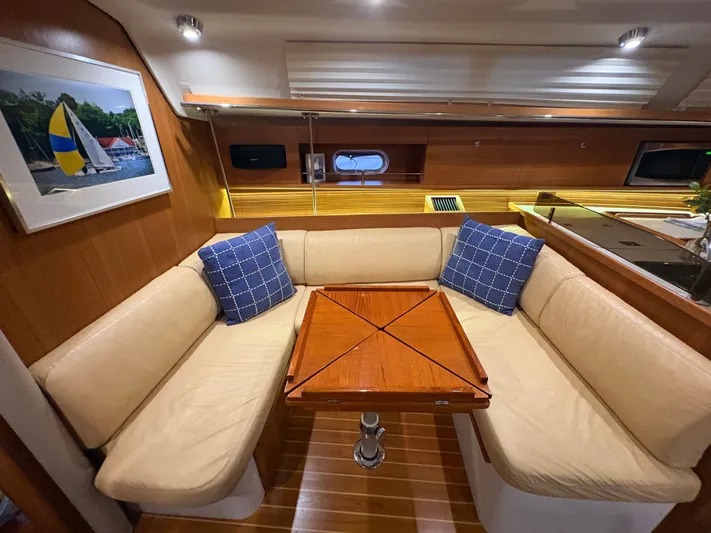 Amadeus Yacht Photos Pics Interior of 2014 Catalina 355 yacht with cozy seating and elegant wooden table.