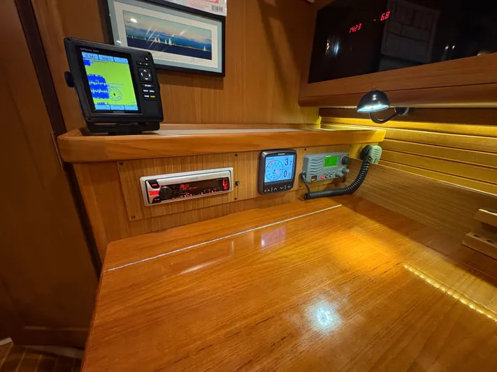 Amadeus Yacht Photos Pics Navigation station in a 2014 Catalina 355 sailboat with electronic displays and wood finish.