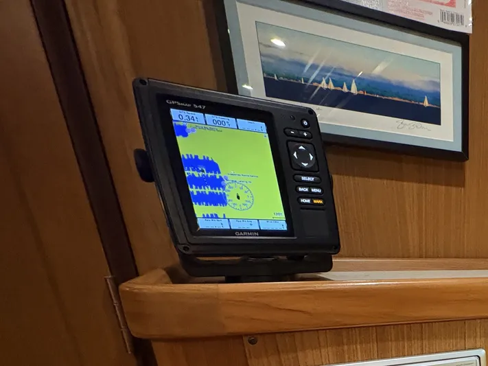 Amadeus Yacht Photos Pics Garmin GPS device on 2014 Catalina 355 yacht interior, with framed artwork in the background.