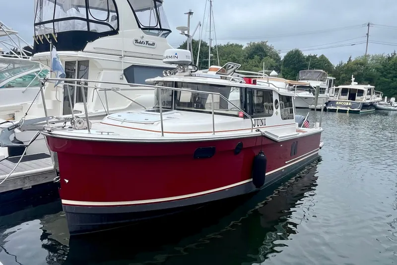  Yacht Photos Pics 2023 Ranger Tugs R-27 boat docked in a marina, featuring a red hull.