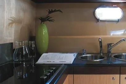  Yacht Photos Pics 2007 Ferretti Yachts 591 kitchen with modern sink, green vase, and countertop accessories.