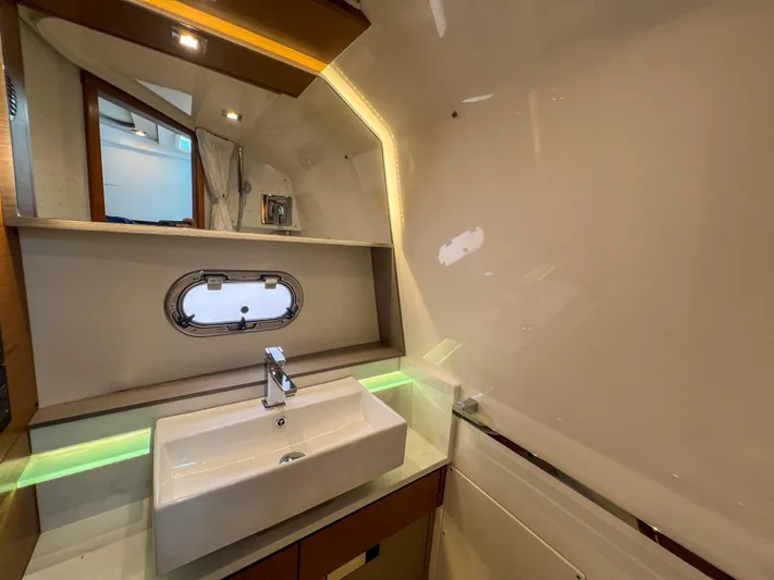  Yacht Photos Pics 2023 Tiara Yachts 38 LS bathroom with modern sink and porthole window.