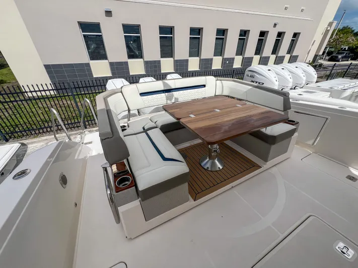  Yacht Photos Pics 2023 Tiara Yachts 38 LS with elegant seating and wooden table on deck.