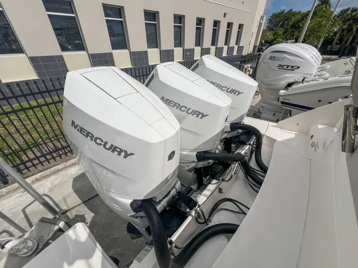  Yacht Photos Pics 2023 Tiara Yachts 38 LS with triple Mercury outboard engines, docked outdoors.