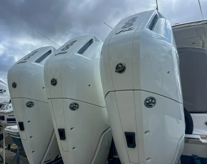  Yacht Photos Pics 2023 Tiara Yachts 38 LS with triple outboard engines under cloudy sky.