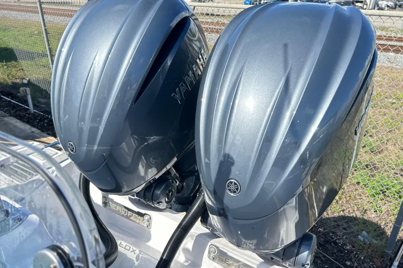  Yacht Photos Pics 2026 Sea Fox 288 Commander with dual Yamaha outboard engines, parked near a fence.