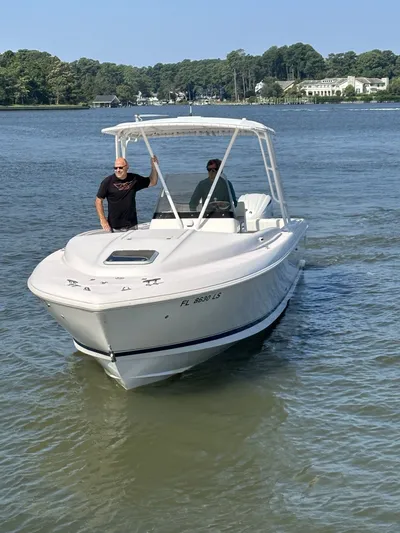  Yacht Photos Pics 2002 Intrepid 323 Cuddy boat on calm water with two people onboard.